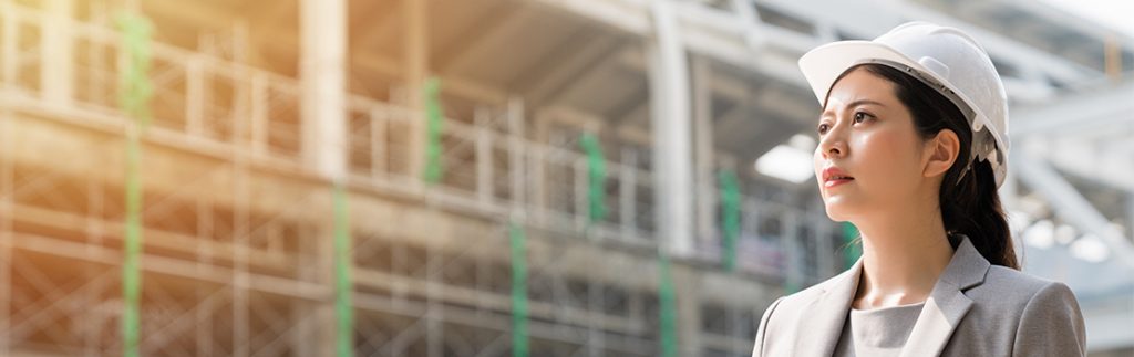 一个女人穿着西装和安全帽调查建筑工地