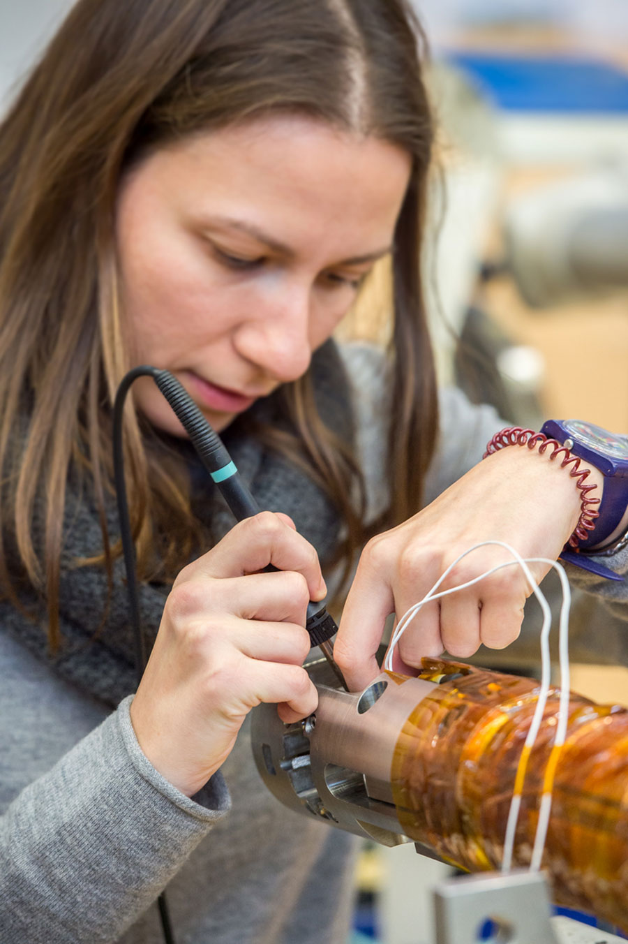年轻白种妇女持有测量工具并持有新超导体内线段,这是未来相撞器可用成份